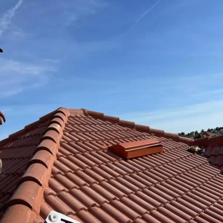 Close-up view of a residential tile roof showing the installed roofing tiles and finished roof surface.